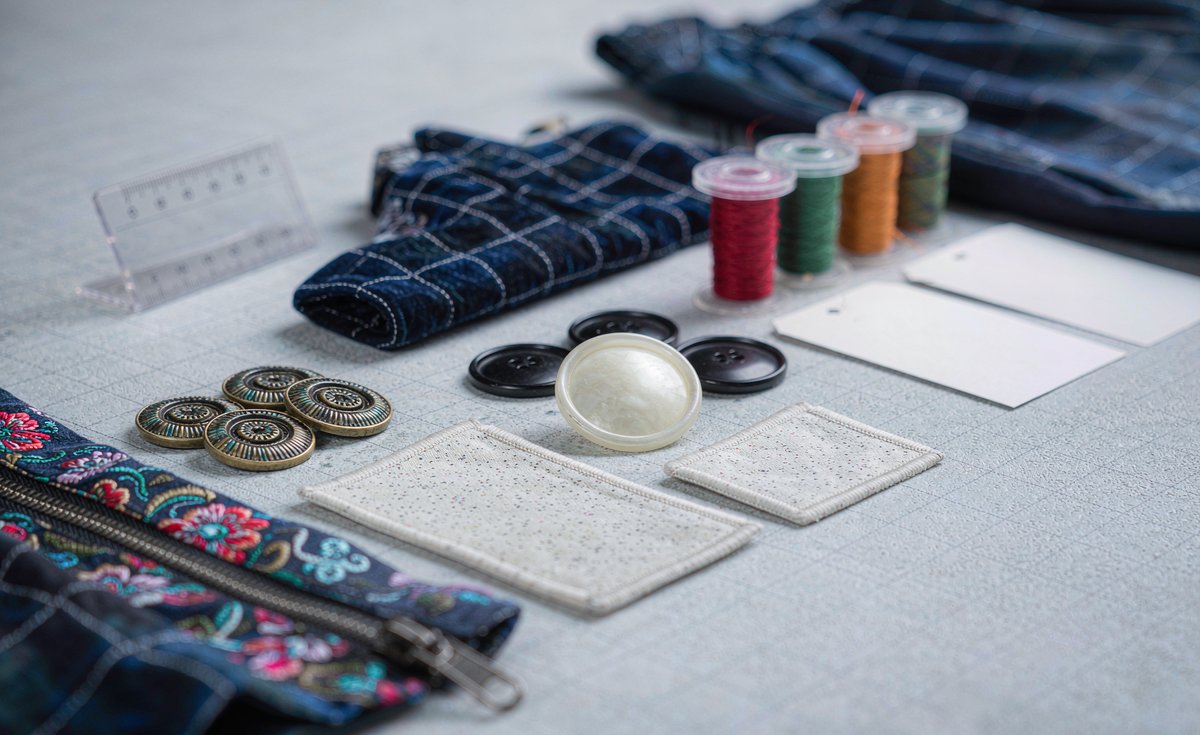 Trims and accessories laid out for costing - buttons, labels, zips and thread - GorgeousBen hidden costs guide